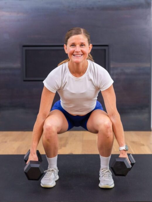 woman performing a dumbbell squat as part of at home full body workout