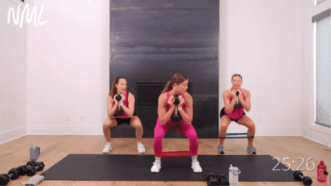 group of standing women performing side to side squats