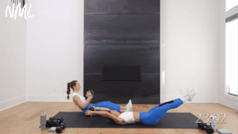 seated women performing a reverse crunch and twist