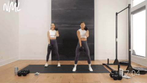 two women performing an uneven squat and bicep curl as part of full body abs workout