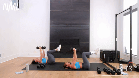 two women performing chest fly knee tucks in a full body workout with weights