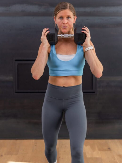woman holding a dumbbell in front of her chest in a full body workout