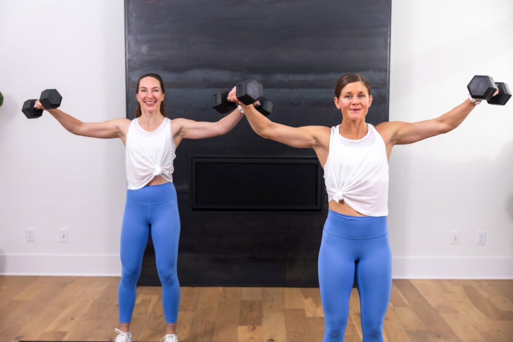 two women performing lat raises as example of arm strengthening exercise