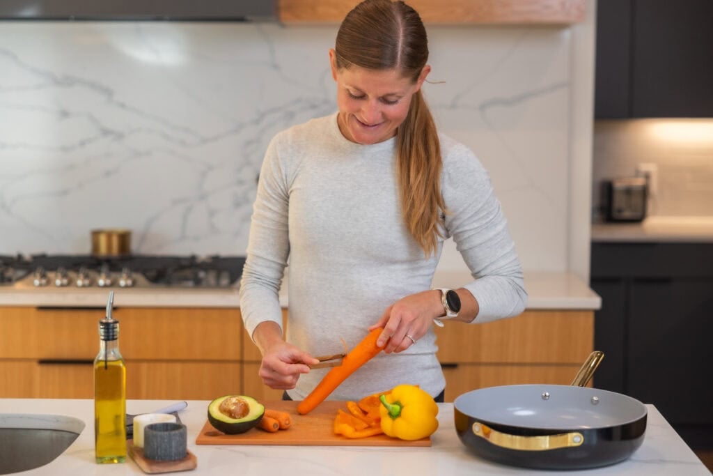 Women performing carrots, veggies and avocado as part of a high protein vegetarian recipe. 