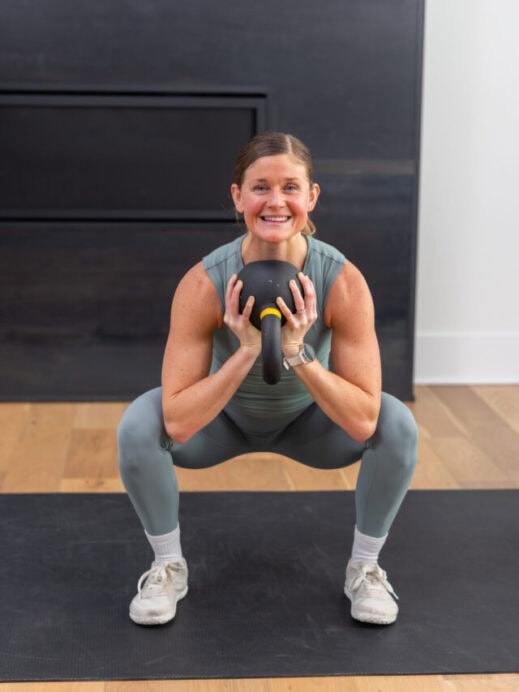 woman performing a goblet squat in a full body kettlebell workout