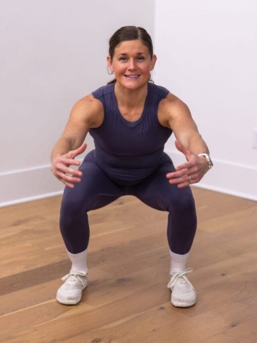woman performing air squats as part of demonstration of how to do a murph workout
