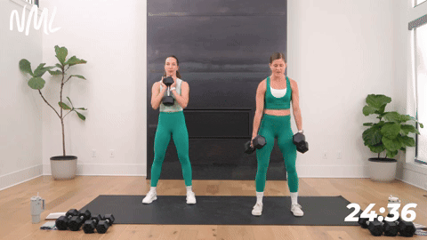 two women performing eccentric squats with dumbbells in a leg and glute workout