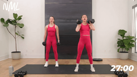 two women performing a front squat with dumbbells in a strength workout for runners