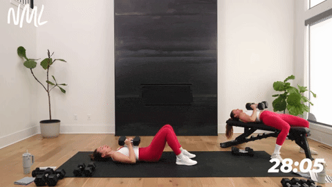 two women performing a narrow chest press with dumbbells in a chest shoulders and triceps workout