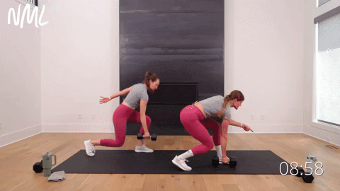 two women performing a lunge and high pull with a cross body crunch in a cardio workout with weights
