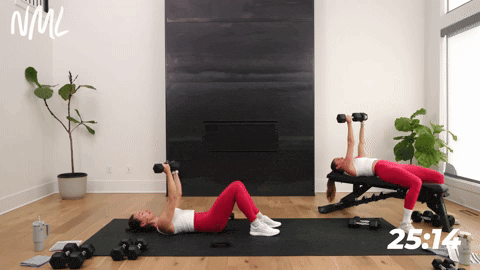 two women performing a rotational chest fly with dumbbells in a chest shoulders and triceps workout