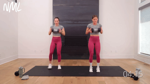 two women performing a dumbbell deadlift clean and side step squat thruster in a cardio workout with weights