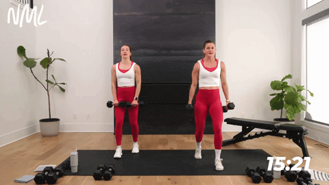 two women performing a front raise with dumbbells in a chest shoulders and triceps workout