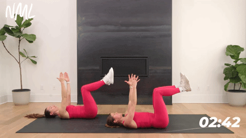 two women performing dead bugs in a core workout for runners