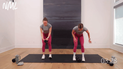 two women performing an uneven dumbbell ground pound in a cardio workout with weights