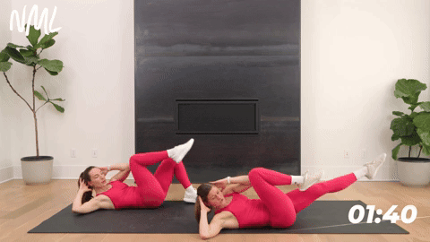 two women performing bicycle crunches in a core workout for runners