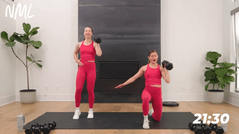 two women performing a single arm clean and press in a strength workout for runners