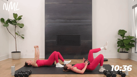 two women performing a single leg glute bridge in a strength workout for runners