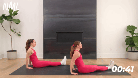 two women performing v sit straight leg lifts in a core workout for runners
