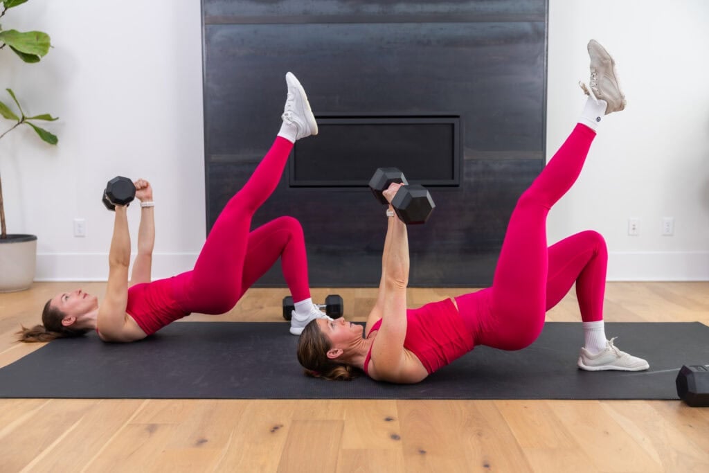 two women performing a single leg glute bridge hold and single arm chest press in a strength workout for runners