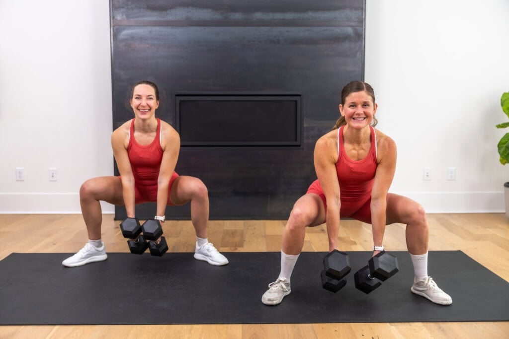 Two women performing a dumbbell sumo squat | glute and hamstring workout