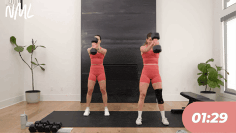 Two women performing dumbbell swings.