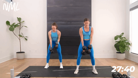 Two women performing a squat and rotational clean with two dumbbells