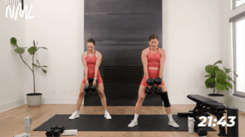 Two women performing a sumo deadlift clean squat.
