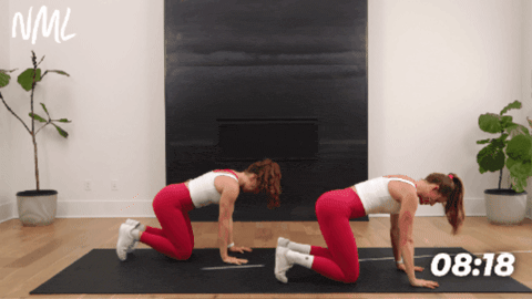 two women performing a bear crawl to activate deep core muscles