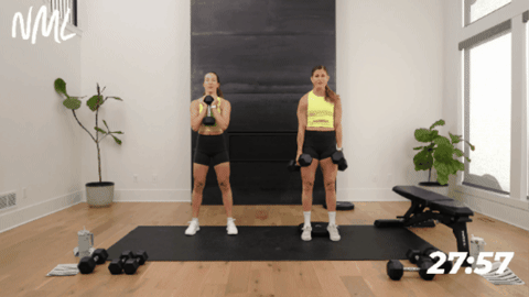 two women performing a squat with their heels elevated to increase quad engagement
