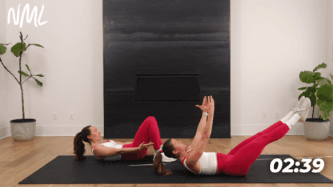 two women on their backs performing a hollow rock hold as example of deep core exercise