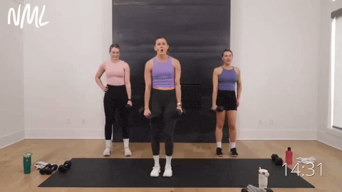 three women performing a lateral lunge with dumbbells in a leg workout