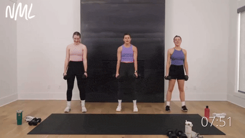 three women performing a dumbbell squat and plank walkout and crossbody knee drive in a leg workout
