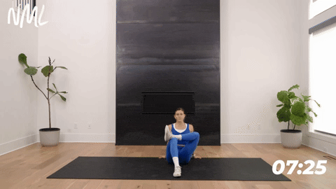 Women performing a seated figure four stretch.