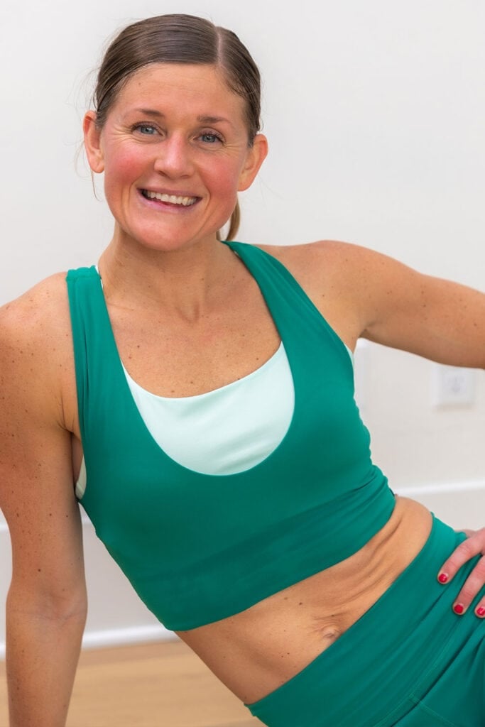 Woman sitting and flexing abs as part of summer ab challenge day 1: ab and booty workout