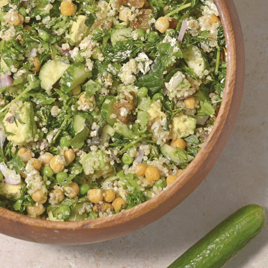 High protein green goddess salad with chickpeas, chicken, cucumbers, avocado, kales, onions and quinoa.
