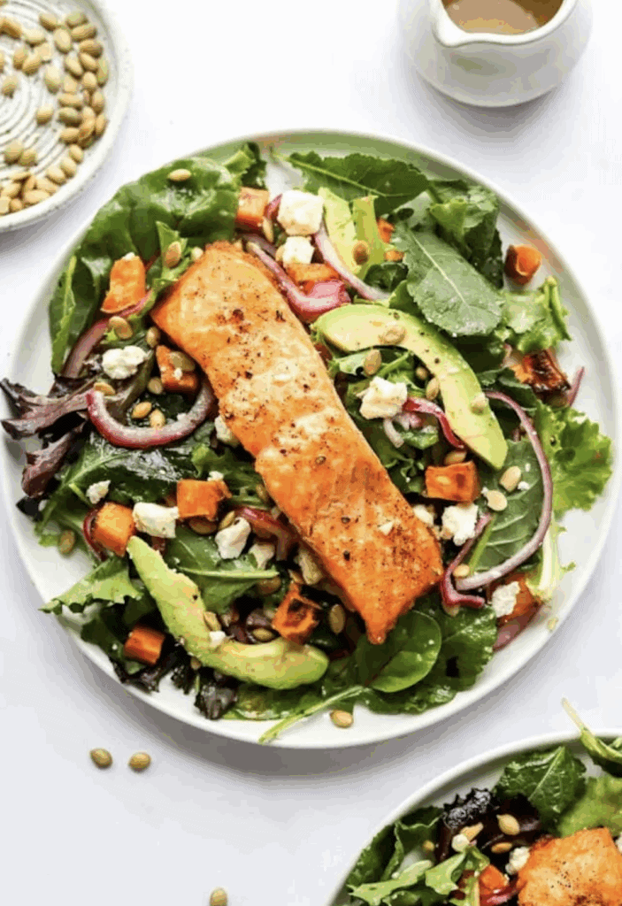 Superfood Salmon Salad with mixed greens, avocado, onion, sweet potatoes, onions and blue cheese crumbles.