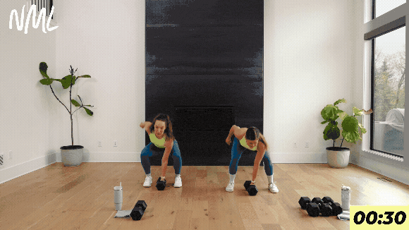 two women performing dumbbell snatches