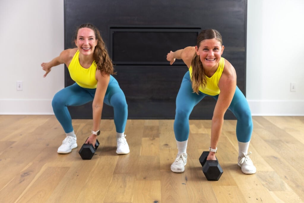 women performing a dumbbell snatch to prepare for hyrox workout