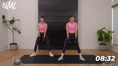 two women performing sumo squats with dumbbells in an inner thigh workout