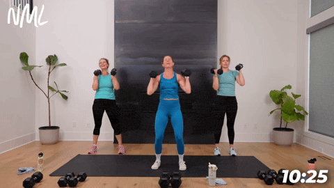 three women performing dumbbell shoulder presses in a strength building workout