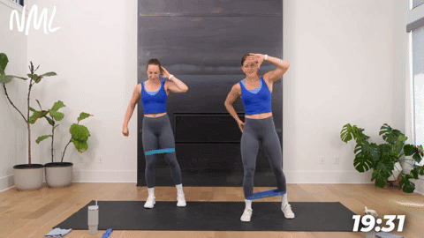 two women performing banded leg lifts in a booty band workout