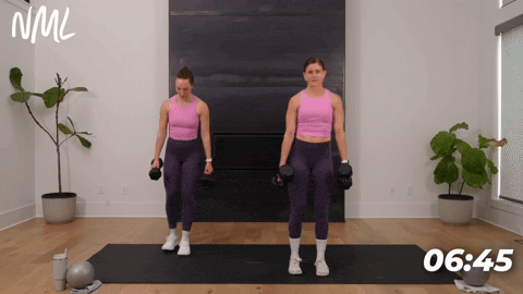 two women performing curtsy lunges with dumbbells in an inner thigh workout