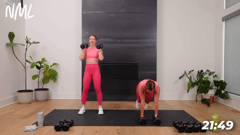 woman performing a dumbbell burpee and woman performing a squat thruster in a full body conditioning workout