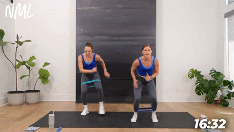 two women performing banded wide to narrow squats in a booty band workout