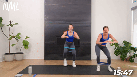 two women performing banded squat walks in a booty band workout