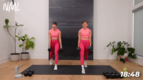 two women performing split lunges with dumbbells in a full body strength and conditioning workout