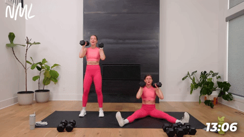 two women performing alternating shoulder presses in a full body workout