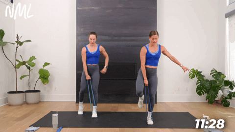 two women performing single leg deadlifts with a resistance band in a booty band workout