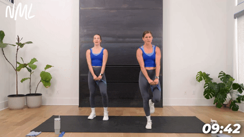 two women performing banded balance chops in a booty band workout
